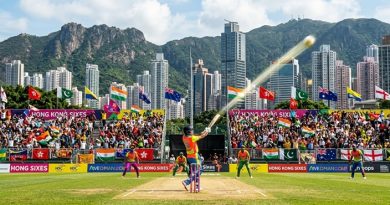 Action shot of a batsman hitting a six at Mission Road Ground during the Hong Kong Sixes tournament with Hong Kong city skyline in the background